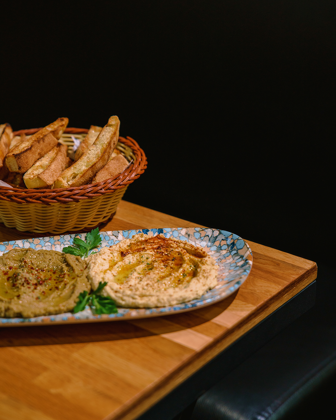 Hummus y baba ganoush con pan caliente servidos en Mania